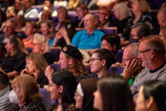 Crowd of people sitting in a auditorium 